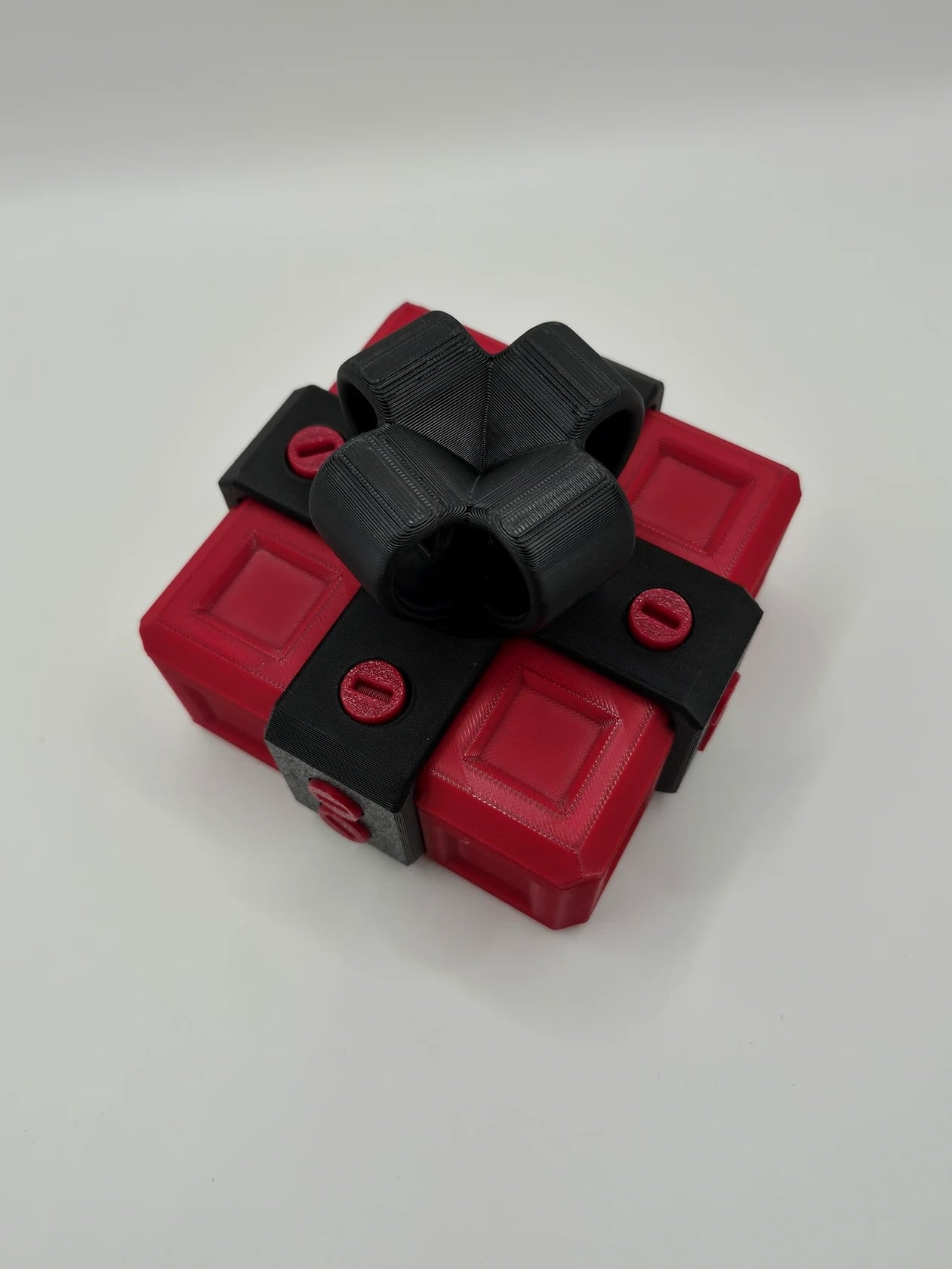 Małe czerwone pudełko na prezent z czarną kokardą – łamigłówka 3D - zdjęcie 2